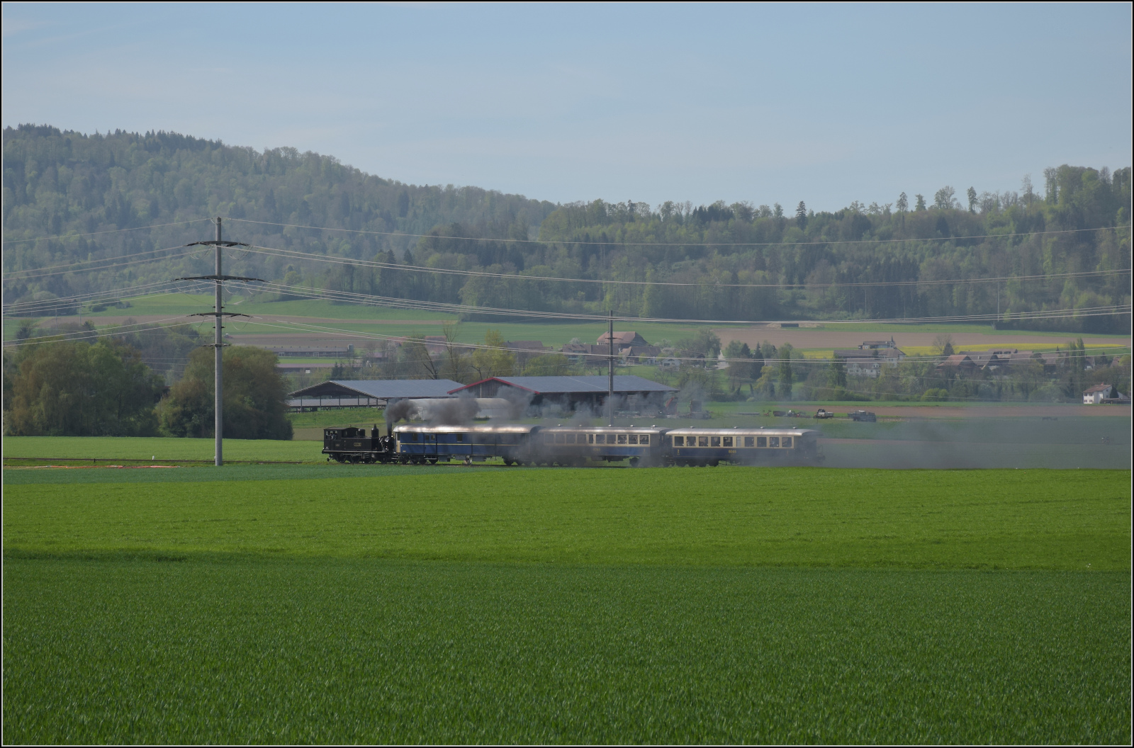 Saisonstart auf dem Schweizerbhnle.

Vom Wiitfeld bei Ramsen kann die Fahrt der Jura-Simplon Eb 2/4 35 durch die ebendiese Weite der Felder nach Hemishofen verfolgt werden. April 2024.