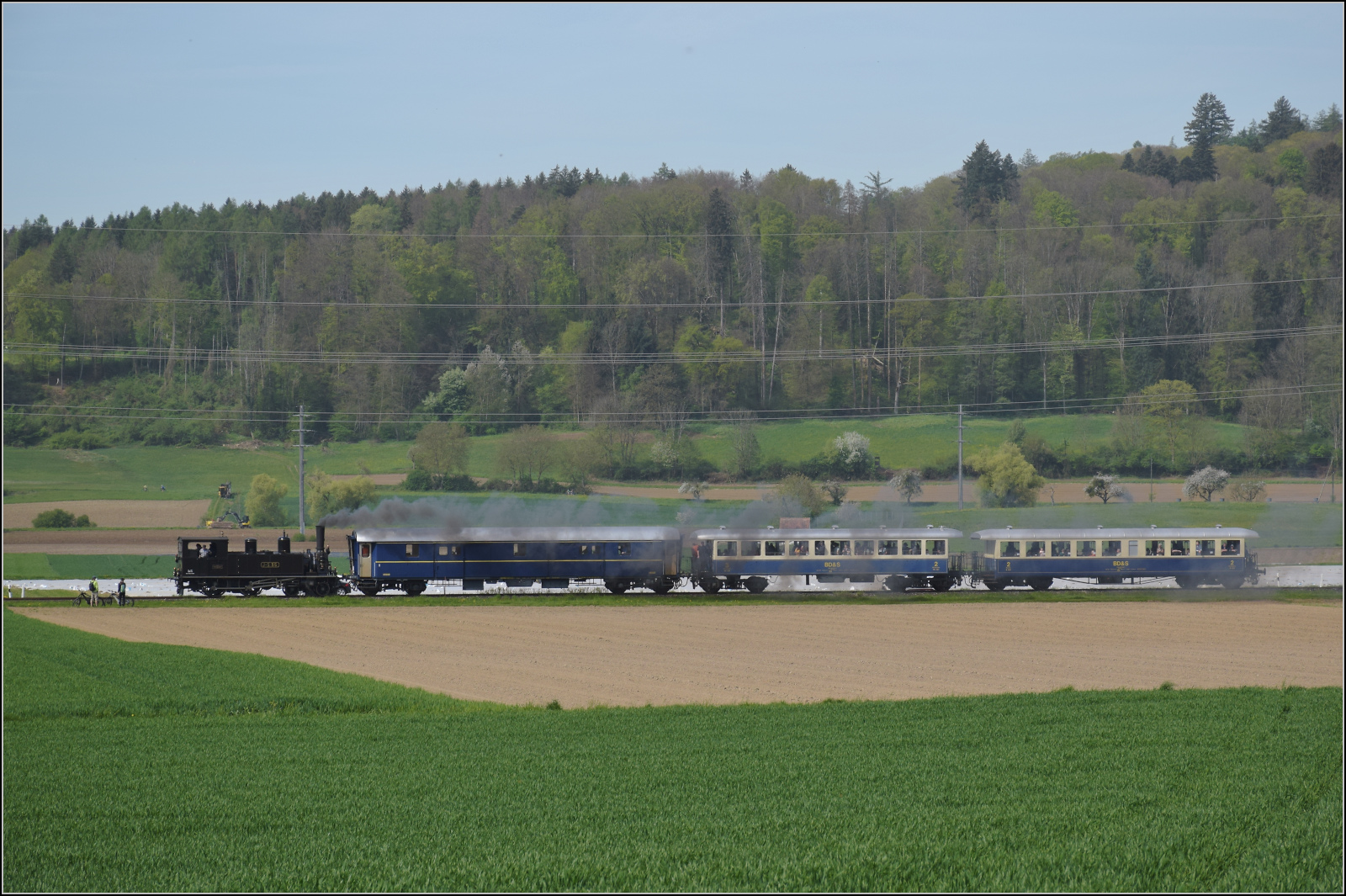 Saisonstart auf dem Schweizerbhnle.

Vom Wiitfeld bei Ramsen kann die Fahrt der Jura-Simplon Eb 2/4 35 durch die ebendiese Weite der Felder nach Hemishofen verfolgt werden. April 2024.