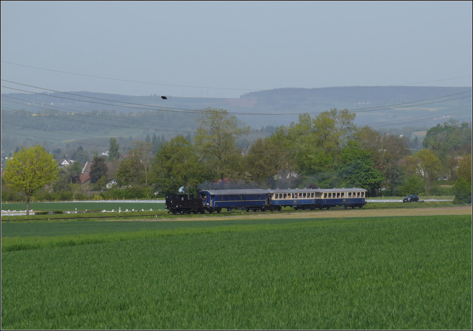 Saisonstart auf dem Schweizerbähnle.

Vom Wiitfeld bei Ramsen kann die Fahrt der Jura-Simplon Eb 2/4 35 durch die ebendiese Weite der Felder nach Hemishofen verfolgt werden. April 2024.