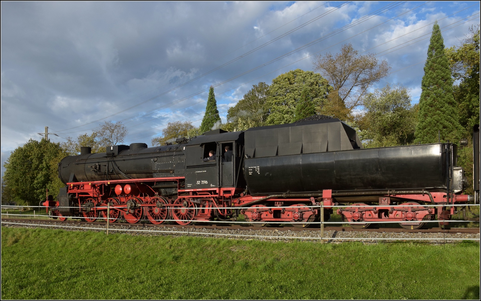 Schienenverkehr am Schienerberg. 

52 7596 mit ihrem EFZ-Sonderzug für die SEHR&RS zwischen Hemishofen und Ramsen auf der letzten Fahrt des Tages. Oktober 2022.