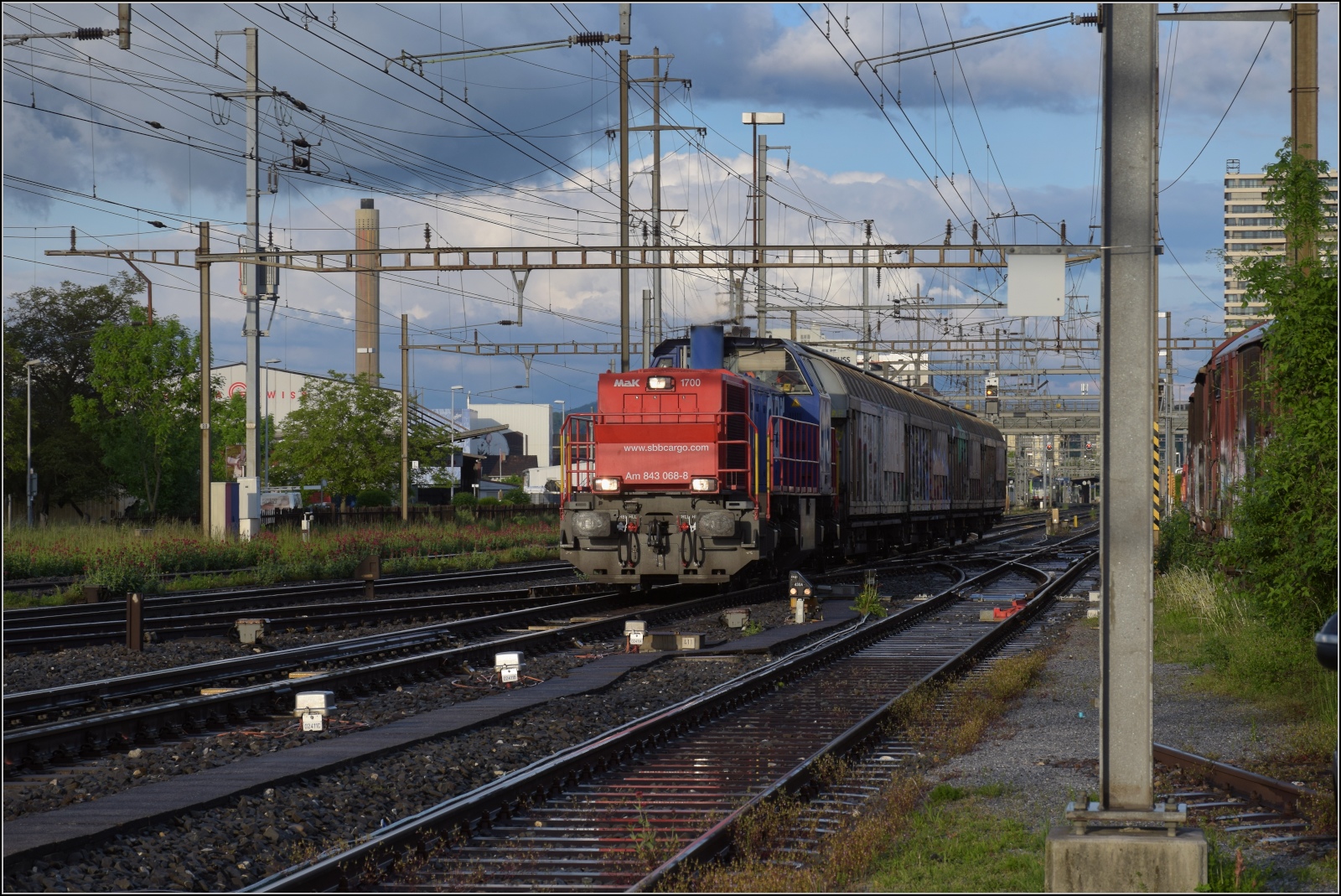 Schlechtwettertag in Pratteln. 

Ein Nahgüterzug mit Am 843 068 kommt die Hauensteinlinie entlanggefahren. Mai 2023.