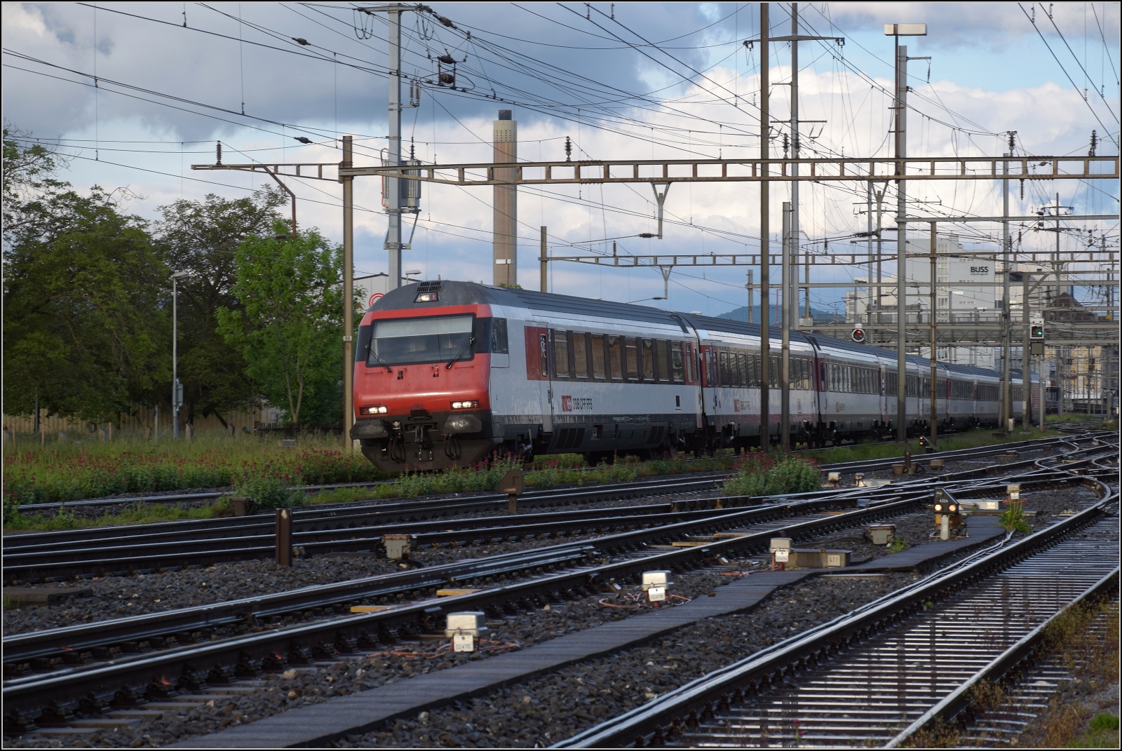 Schlechtwettertag in Pratteln. 

Re 460 031 schiebt einen Interregio rheinabwärts nach Basel. Mai 2023.