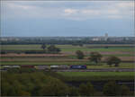 kbs-702-offenburg-basel-rheintalbahn/865443/markgraefler-land-vor-dem-fall-der Markgräfler Land vor dem Fall der Blätter.

Re 482 015 oder Re 482 028 mit 'ChemOil'-Werbung bei Auggen. Oktober 2024.