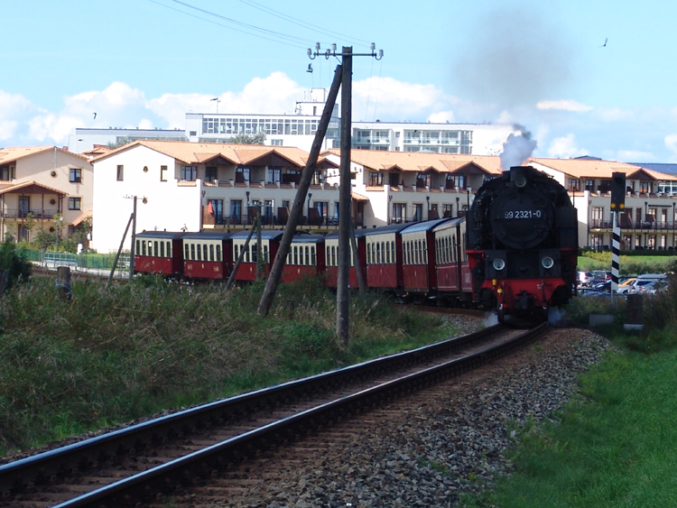 99 2321-0 mit MBB14621 von Ostseebad Khlungsborn West Richtung 
Bad Doberan im Hintergrund die Skyline von Khlungsborn.(05.09.10)