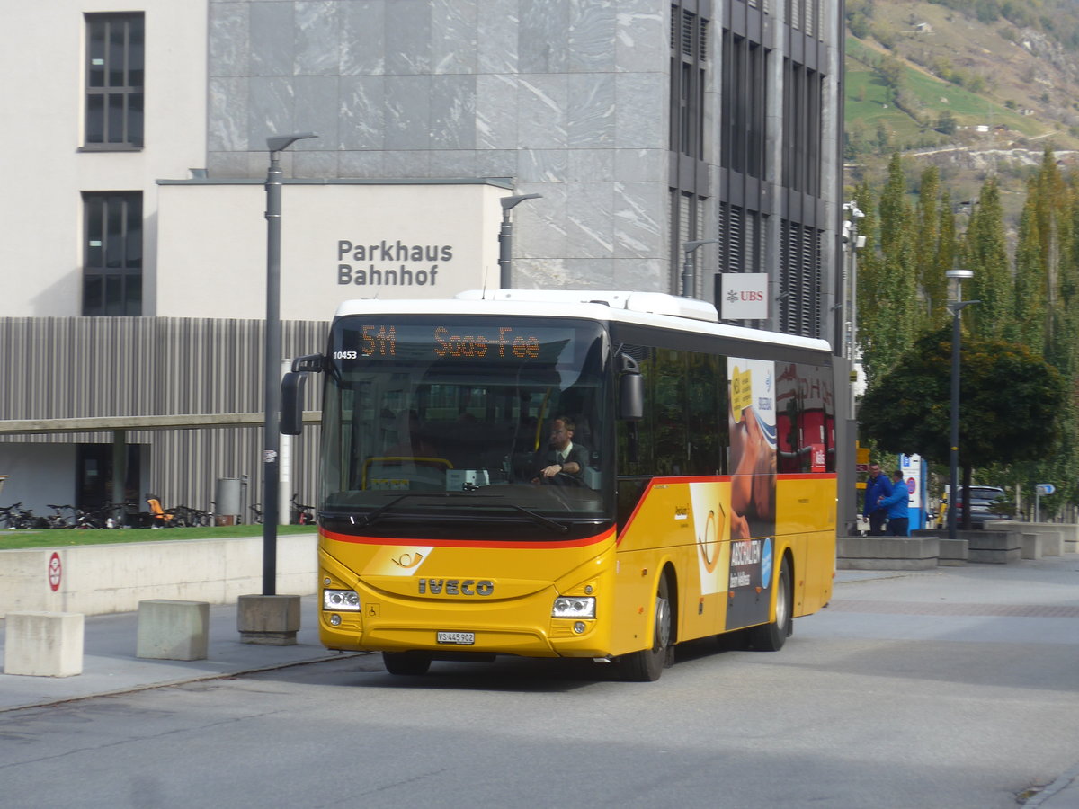 (210'673) - PostAuto Wallis - VS 445'902 - Iveco am 27. Oktober 2019 beim Bahnhof Visp