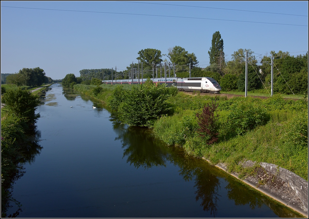 Am Rhein-Rhone-Kanal.

Die TGV-Einheit der neuesten Generation eilt auf der schwach frequentierten Altstrecke Richtung Paris entlang des Rhein-Rhone-Kanals. Der Zug Nr 816 hat eine Luxemburgzulassung, auch wenn er nicht in diese Richtung fährt. Die Triebköpfe haben die Nummern 93 87 0310 231-0 F-SNCF und 232-8. Brunstatt, Juli 2021. 