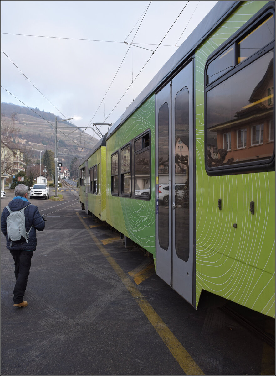 Beh 4/8 91 wartet im Bahnhof Bex auf Abfahrt. Der Haltepunkt ist - wie früher oft - einfach das Strassenplanum. Da ist ein Niederflurtriebwagen auch eine Einstiegsherausforderung für nicht geländegängige Personen, die anderen  steigen auf einen Stuhl .  Januar 2026.
