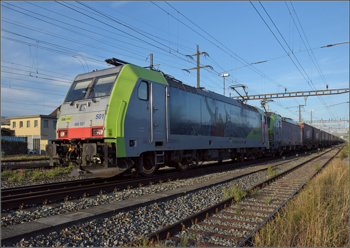 Re 486 501 und Re 475 410 in Pratteln. August 2026.