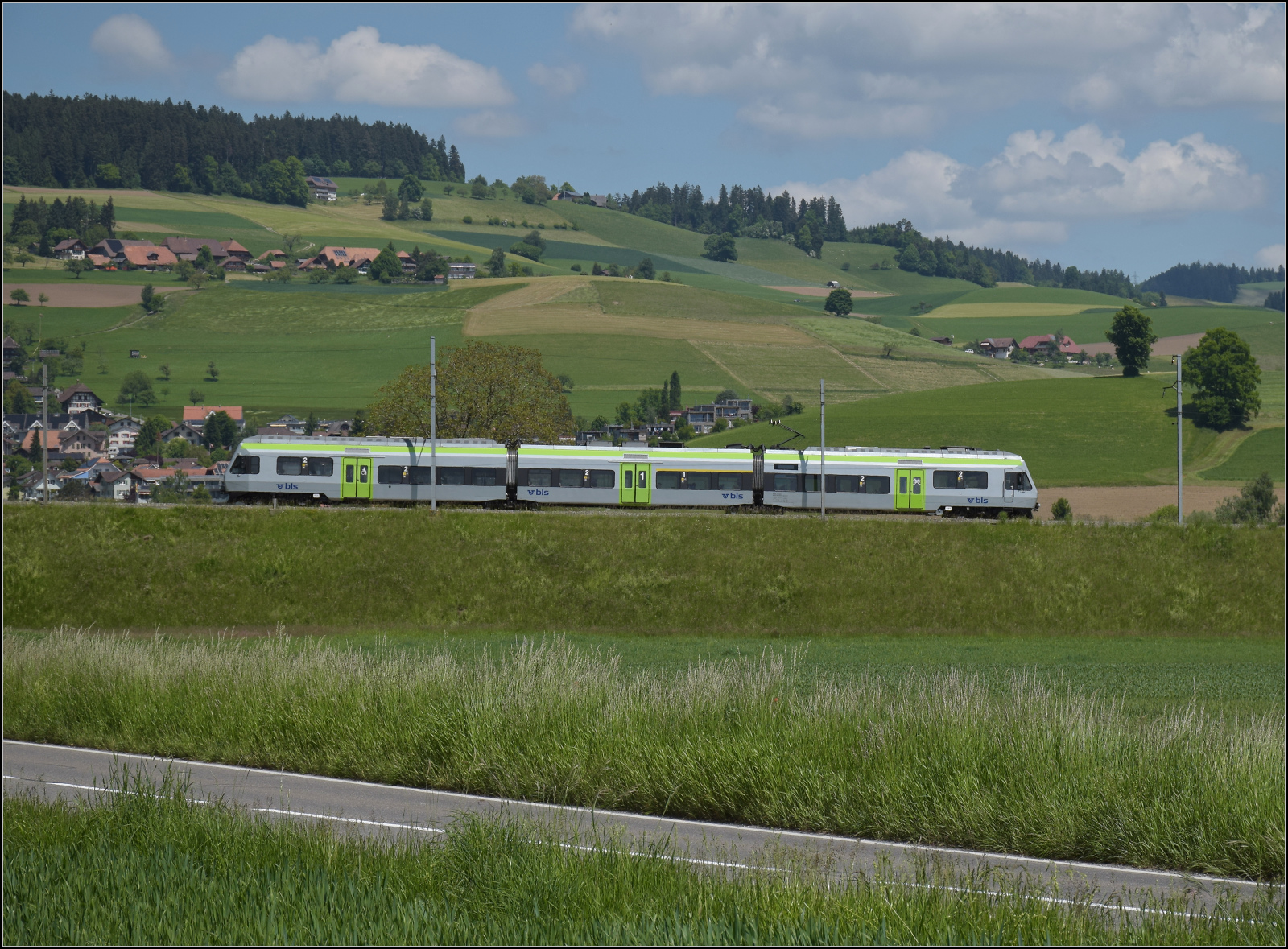 150 Jahre Emmentalbahn. 

Die Rampe von Konolfingen nach Grosshöchstetten (im Hintergrund) fährt nach dem mittlerweile historischen NPZ noch eine dreiteilige Nina RABe 525 hinunter. Konolfingen Dorf, Mai 2025.