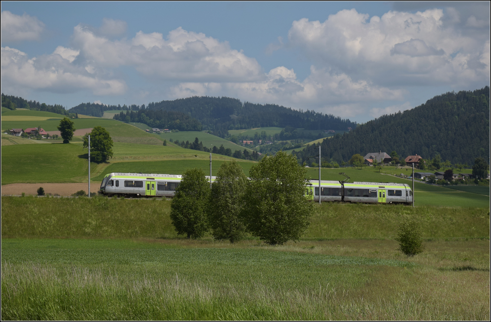 150 Jahre Emmentalbahn. 

Die Rampe von Konolfingen nach Grosshöchstetten (im Hintergrund) war einst ein grösseres Betriebshindernis für die Bahn. Die Burgdorf-Thun-Bahn schlug den Steigungsproblemen ein Schnippchen, indem sie von Anfang an mit Drehstrom fuhr. Im ersten Weltkrieg profitierte die Bahn von ihrer nachhaltigen Energieversorgung und profitierte sogar von der Krise. Das hätte man den Herren von Nordstream und Co. mal vor die Nase halten sollen. Der Strom wird zwar heute  als Wechselstrom mit nur einer Phase übertragen, das Prinzip des Drehstromantriebs beherzigt aber der Lötschberger Kollege RABe 535 121, der hier nach Grosshöchstetten hinauffährt. Konolfingen Dorf, Mai 2025.