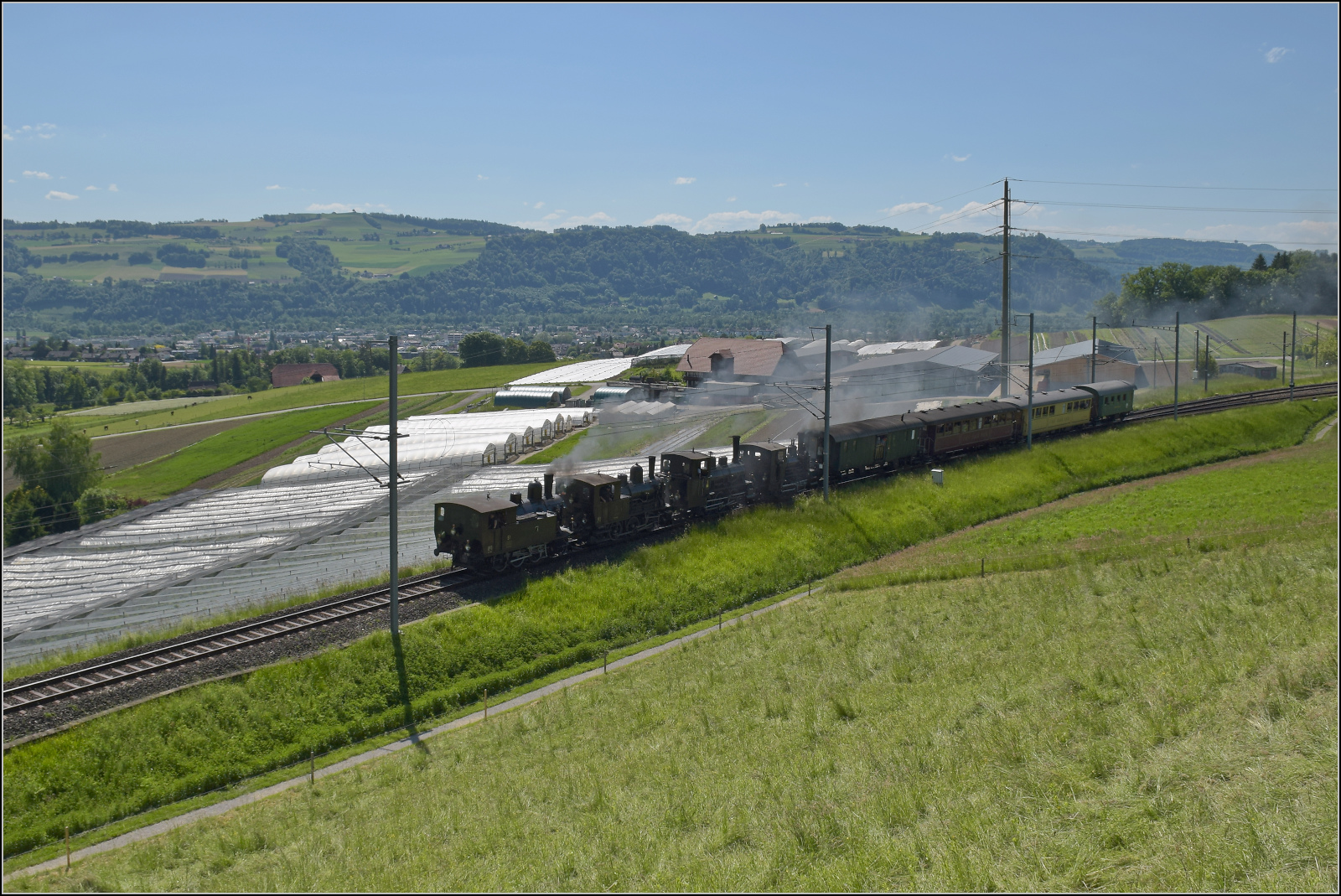 150 Jahre Emmentalbahn. Vierfachtraktion auf Gleisen der Bernischen Staatsbahn.

Zum Abschluss das Fest mit allen vier momentan betriebsfähigen Dampfloks der Dampfbahn Bern. Ed 3/4 51 der Bern-Schwarzenburg-Bahn, E 3/3 1 'Lise'des Gaswerks Bern, Ed 3/3 3 'Langnau' der Emmentalbahn und E 3/3 853 der Jura-Simplon-Bahn. Ein weiter Blick über das Aaretal auf den Belpberg komplettiert die Szene. Tägertschi, Mai 2025.