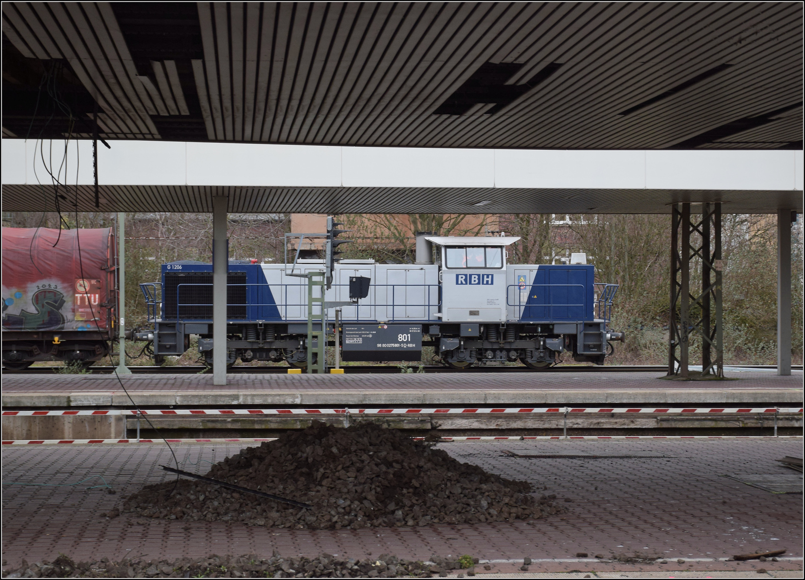 275 801 von RBH fährt mit einem Güterzug an den Bahnsteiggleisen in Duisburg vorbei. Februar 2026.