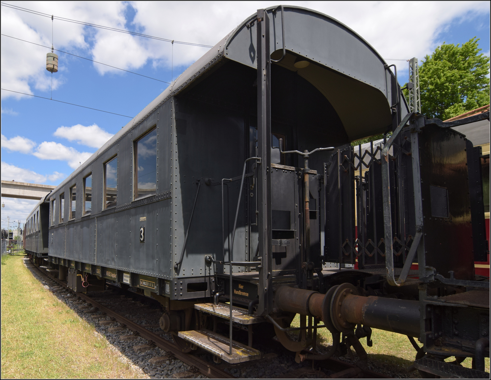 4. Nrdlinger Eisenbahnfest.

Diese Donnerbchse ist eine bayrische Sonderbauart der Einheitswagen mit Elementen bayerischer Personenwagen. Daher ist seine Gattung Ci-bay29. Er ist ein Ganzstahlwagen, dem man fast schon die Weiterentwicklung zu den Wagen mit geschlossenem Einstiegsbereich ansieht. Der Wagen wurde 1930 von Rathgeber geliefert und bekam die Nummer 85 052 Mnchen. Von 1963 an war er bei der DB ein Wohn- und Schlafwagen. Nrdlingen, Juni 2025.
