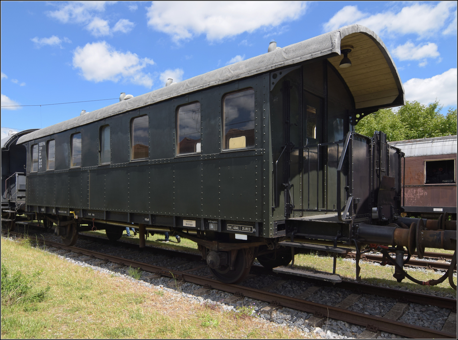 4. Nrdlinger Eisenbahnfest.

Diese Donnerbchse gehrt zur Gattung CDi-23. Der Wagen wurde 1923 von Wegmann geliefert, die 4. Klasse wurde lediglich umbenannt, somit war er ein CCid-23. Bei der Nummernvereinheitlichung 1930 bekam er die Nummer 98 001 Frankfurt. Im Jahr 1934 wurde der nur beschriftungstechnisch abgeschafften 4. Klasse ein Ende bereitet und das Abteil zu einem Traglastenabteil umgebaut. 1963-1983 rettete ihn das Dasein als Wohn- und Schlafwagen. Nrdlingen, Juni 2025.