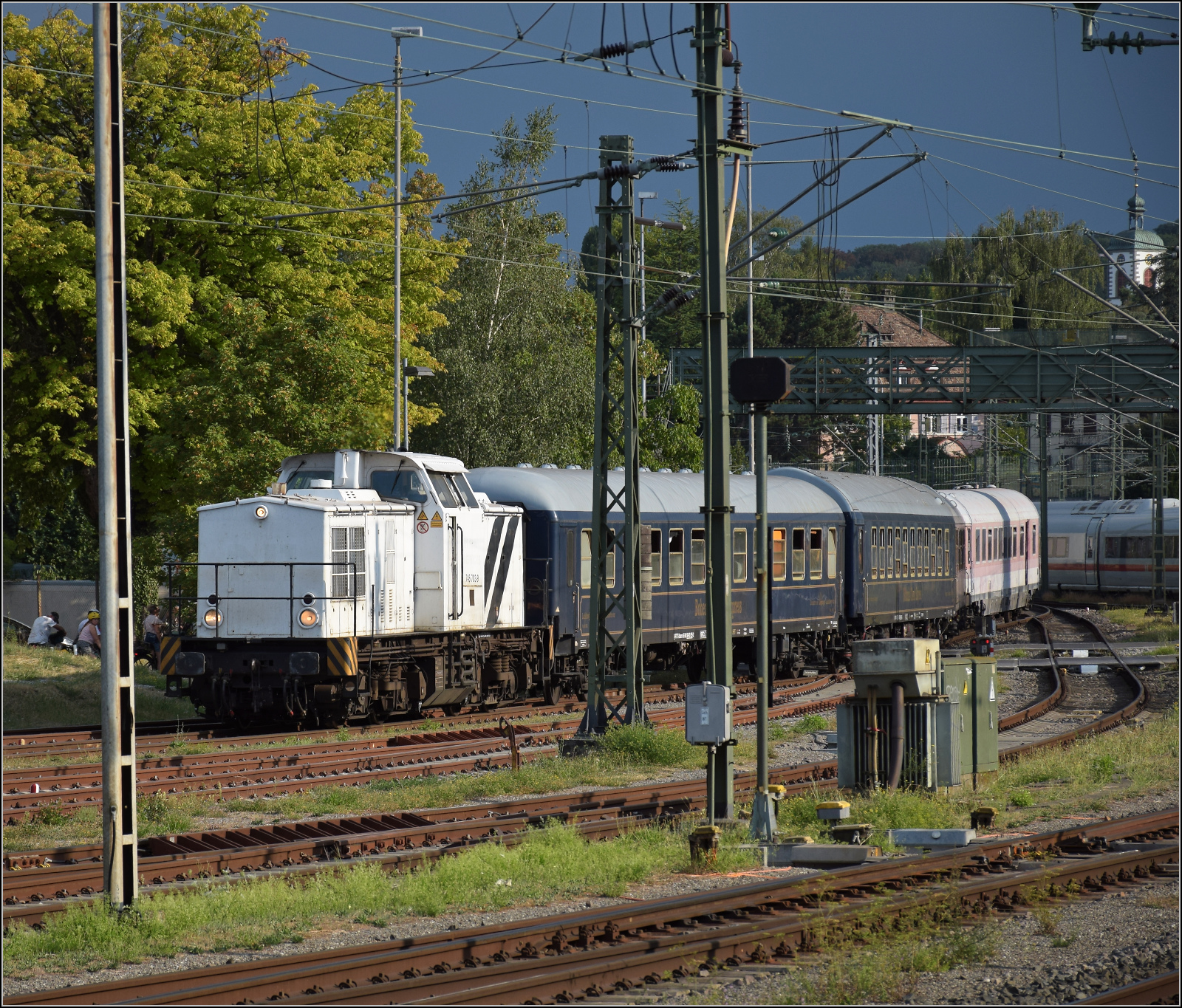 92 54 2745 903-1 CZ-RTTS lautet die Nummer der nach Tschechien eingebürgerten V 100 Ost. Gerade soll sie die Wagen des Bohemian Classic Express auf das Gleis am ehemaligen SBB-Güterschuppen bringen. Konstanz, August 2026.