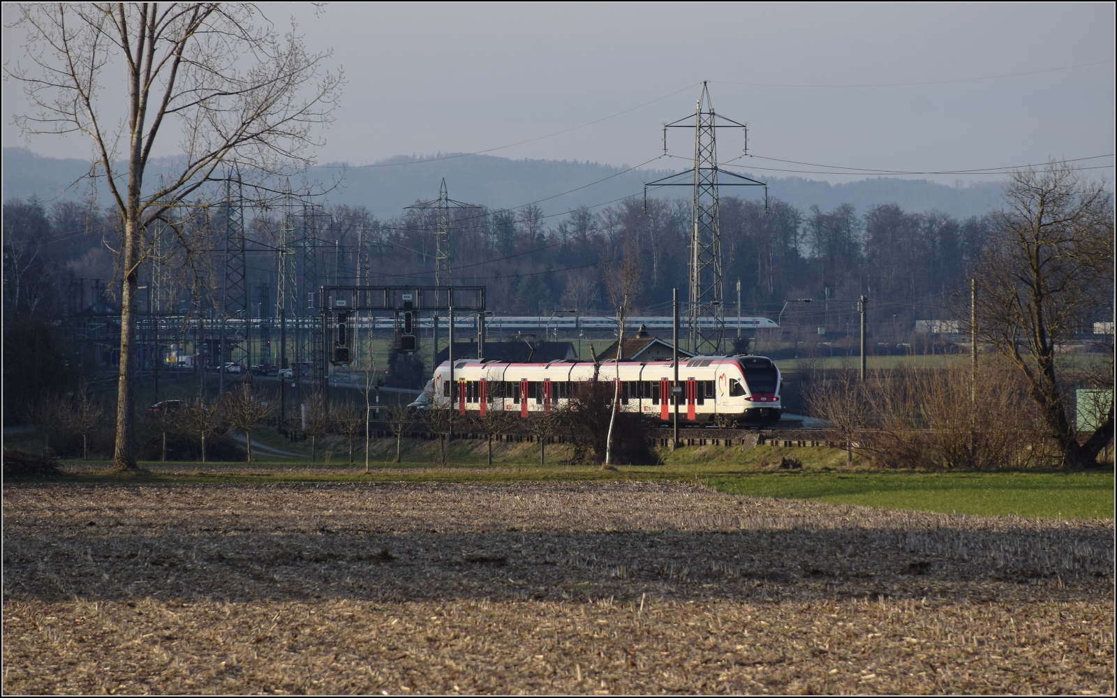 Am fast dauerverschlossenen Bahnbergang.

RABe 521 007 'Gilberte de Courgenay' in Hendschiken. Februar 2023.
