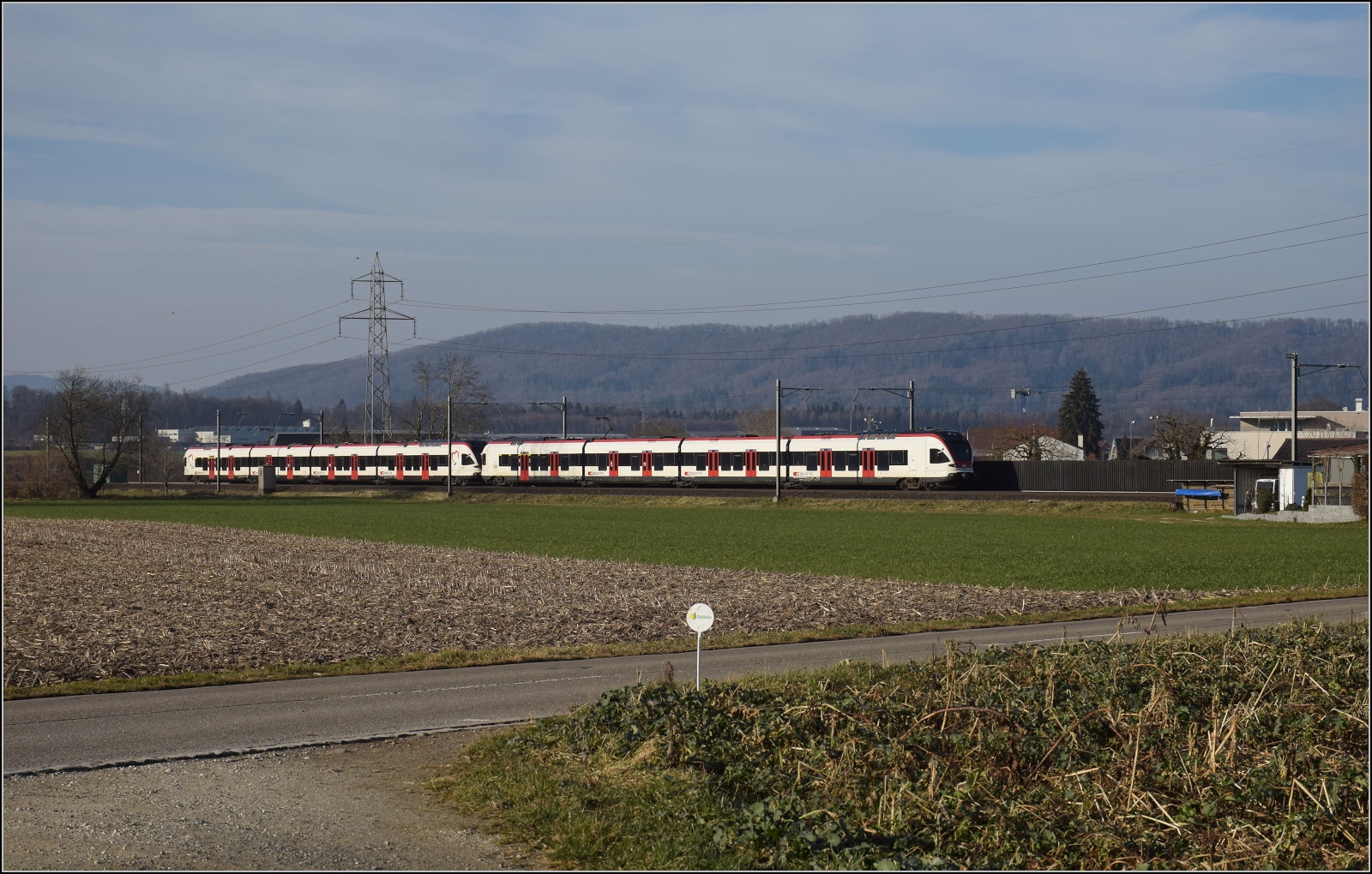 Am fast dauerverschlossenen Bahnübergang.

RABe 523 065 und RABe 521 012 'Olten' in Hendschiken. Februar 2023.