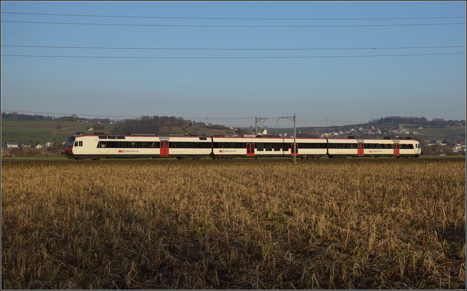 Am fast dauerverschlossenen Bahnübergang.

RBDe 560 277 in Hendschiken. Februar 2023.