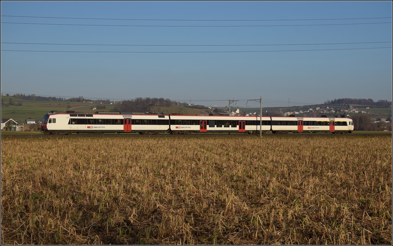 Am fast dauerverschlossenen Bahnübergang.

RBDe 560 277 in Hendschiken. Februar 2023.
