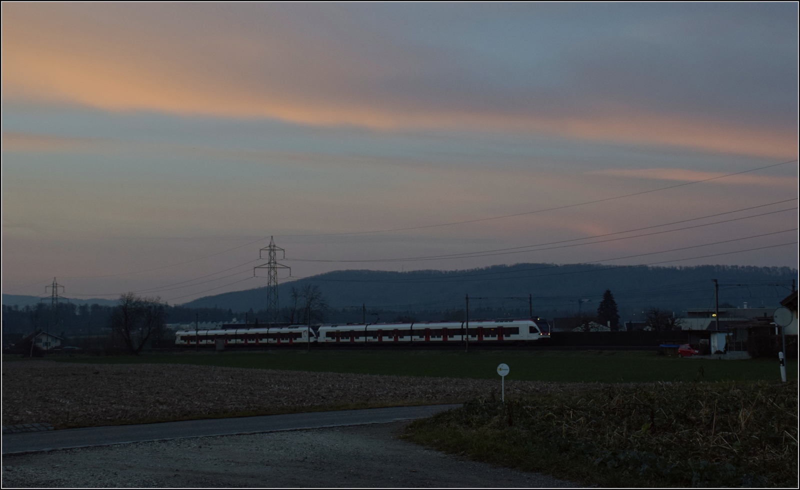 Am fast dauerverschlossenen Bahnübergang.

Zwei unbekannt gebliebene RABe 521 und 523 in Hendschiken. Februar 2023.
