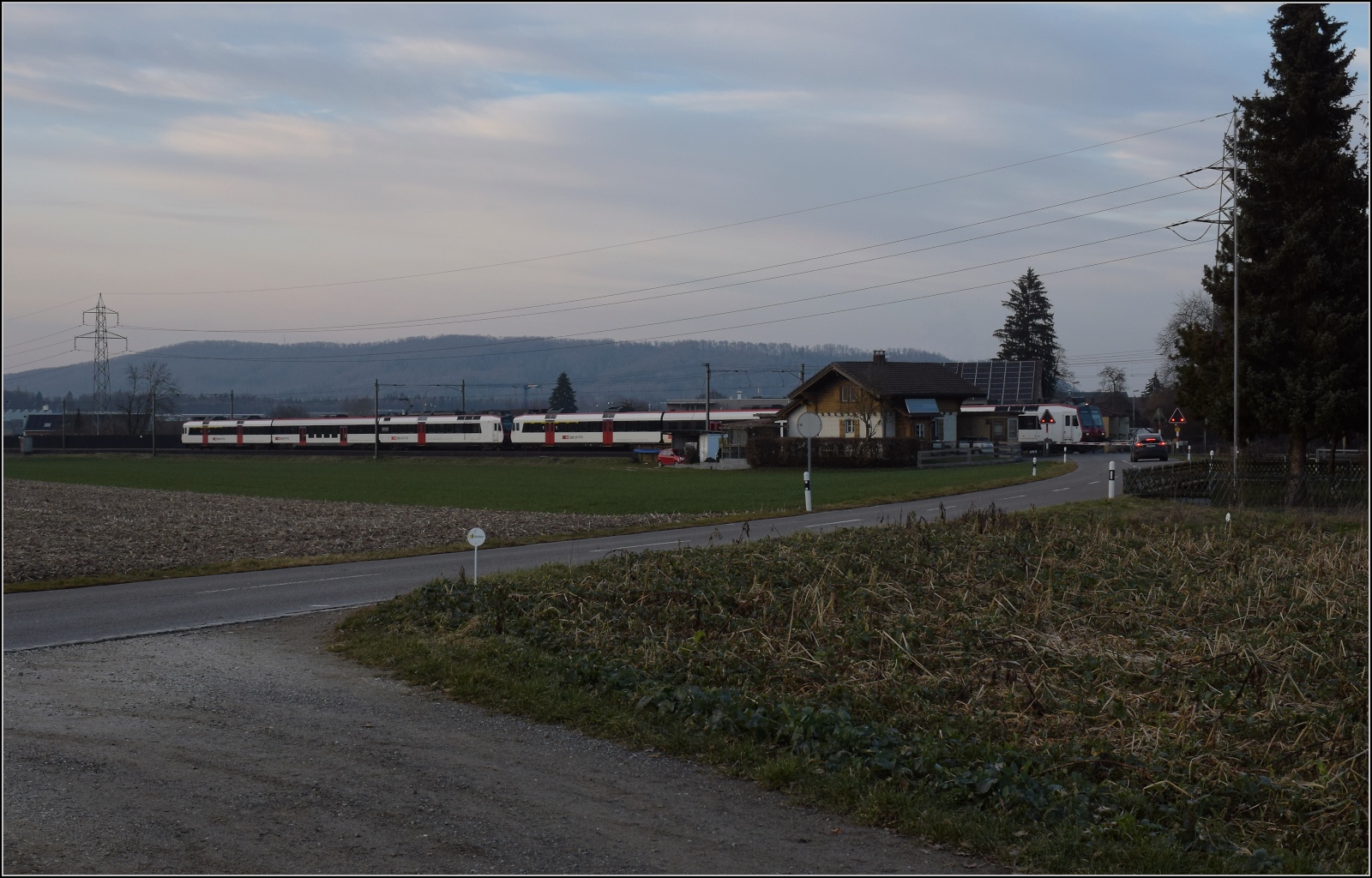 Am fast dauerverschlossenen Bahnübergang.

Zwei unbekannt gebliebene RBDe 560 in Hendschiken. Februar 2023.