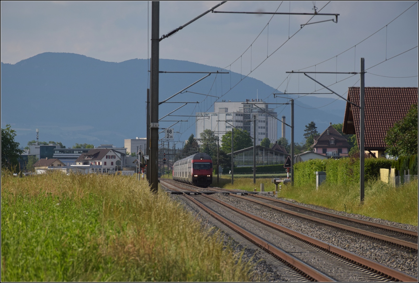 Bahn 2000-Wagen, geschoben von Re 460 110 'Mariaberg' bei Bettenhausen. Juni 2023.