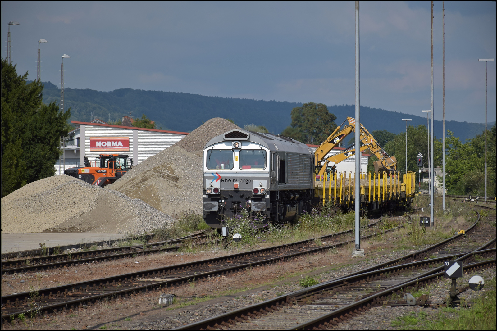Baustelle vor der Baustelle am Hochrhein.

Im Schatten des letzten  deutschen Atomkraftwerks in Betrieb , was den Standort Leibstadt weitgehend in Deutschland beschreibt, ist ein Baggerballett mit der sich selten ein paar Meter bewegenden 266 068 von Rheincargo beschäftigt. Albbruck, August 2025.
