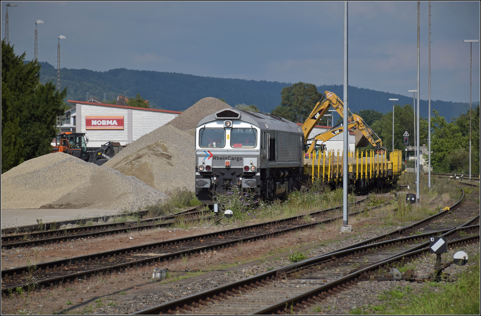 Baustelle vor der Baustelle am Hochrhein.

Im Schatten des letzten  deutschen Atomkraftwerks in Betrieb , was den Standort Leibstadt weitgehend in Deutschland beschreibt, ist ein Baggerballett mit der sich selten ein paar Meter bewegenden 266 068 von Rheincargo beschäftigt. Albbruck, August 2025.