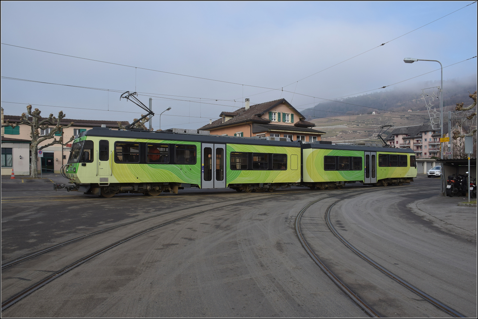 Beh 4/8 91 wartet im Bahnhof Bex auf Abfahrt. Der Haltepunkt ist - wie früher oft - einfach das Strassenplanum. Januar 2026.