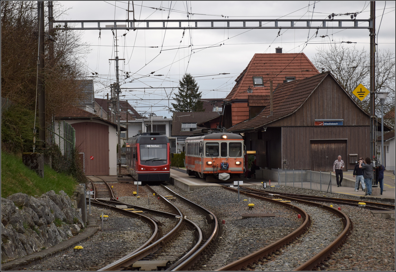 Bierlisi statt Bipperlisi. 

Be 4/4 104 macht in Wiedlisbach einen l�ngeren Zwischen/Pitstop und blockiert ein wenig den Bahnsteig f�r die restlichen Fahrg�ste. Unterdessen nimmt der Be 4/8 113 'Mars' die Fahrg�ste nach Solothurn mit. Februar 2026.