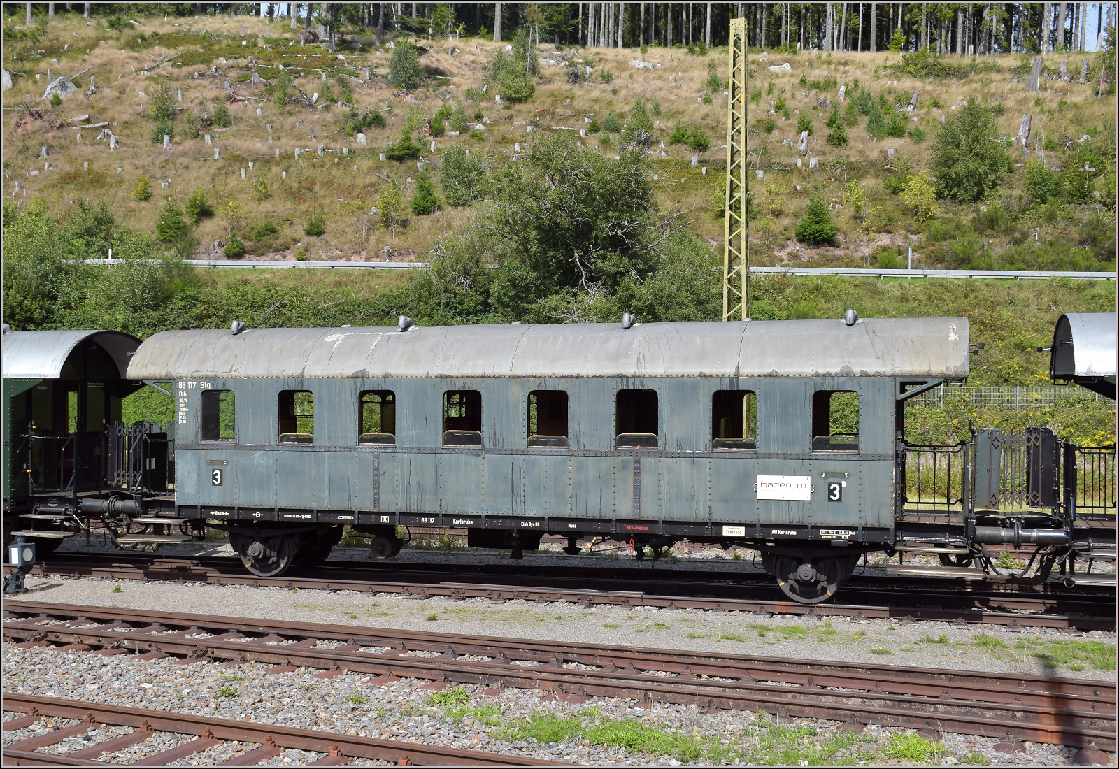 Dampf im Hochschwarzwald. 

23 042 verlsst mit ihrem Museumszug Titisee. Im Bild die Donnerbchse 83 117 Kar der Austauschbauart Gattung Di-27, die kurz darauf in Ciu-27 umgebaut wurde, sprich als 4. Klasse-Wagen noch vor deren Abschaffungen gebaut. berbleibsel der kurz zuvor erfolgten Umstellung auf  die Ganzstahlbauweise ist die Dachsttze der Teilstahlausfhrung, die ein frheres Baudatum vermuten lsst und offenbar noch nicht ganz dem Austauschprinzip folgt. September 2025.