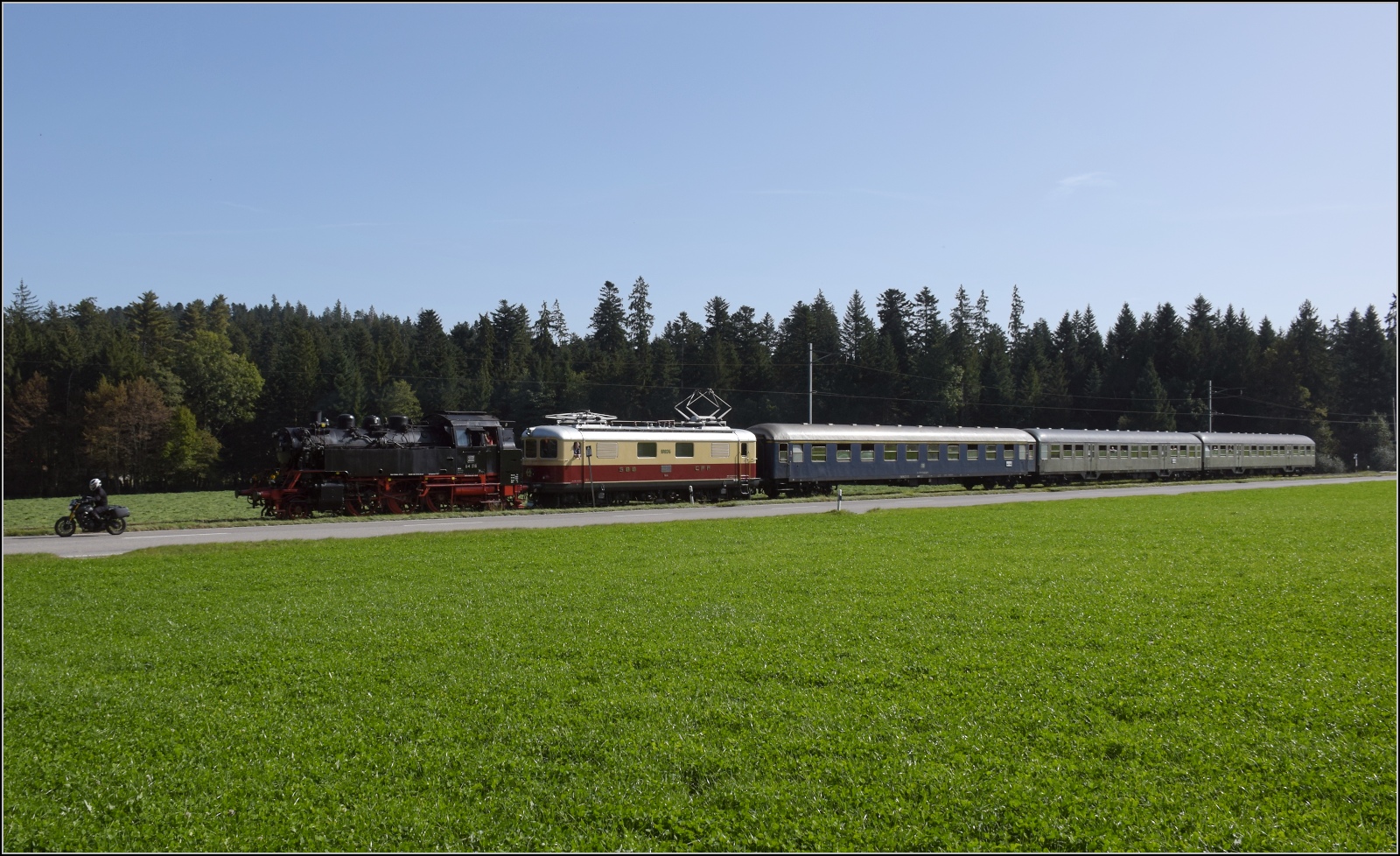 Dampftage Huttwil mit frisch genesenem Bubikopf. 

64 518 und Re 4/4 I 10034 mit zwei Silberlingen und einem erstklassigen Schnellzugwagen der DB im Herrengraben. Oktober 2023