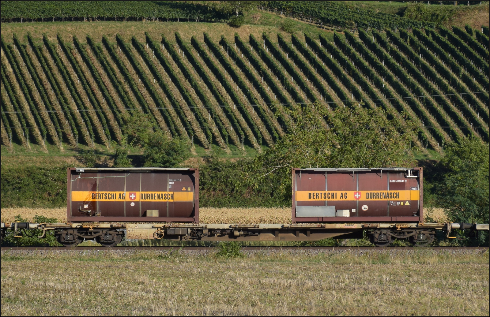 Der Wagen 33 85 4575 330-7 TEN CH-HUPAC Sgnss im Zugverband mit Re 482 030. Buggingen, September 2026.