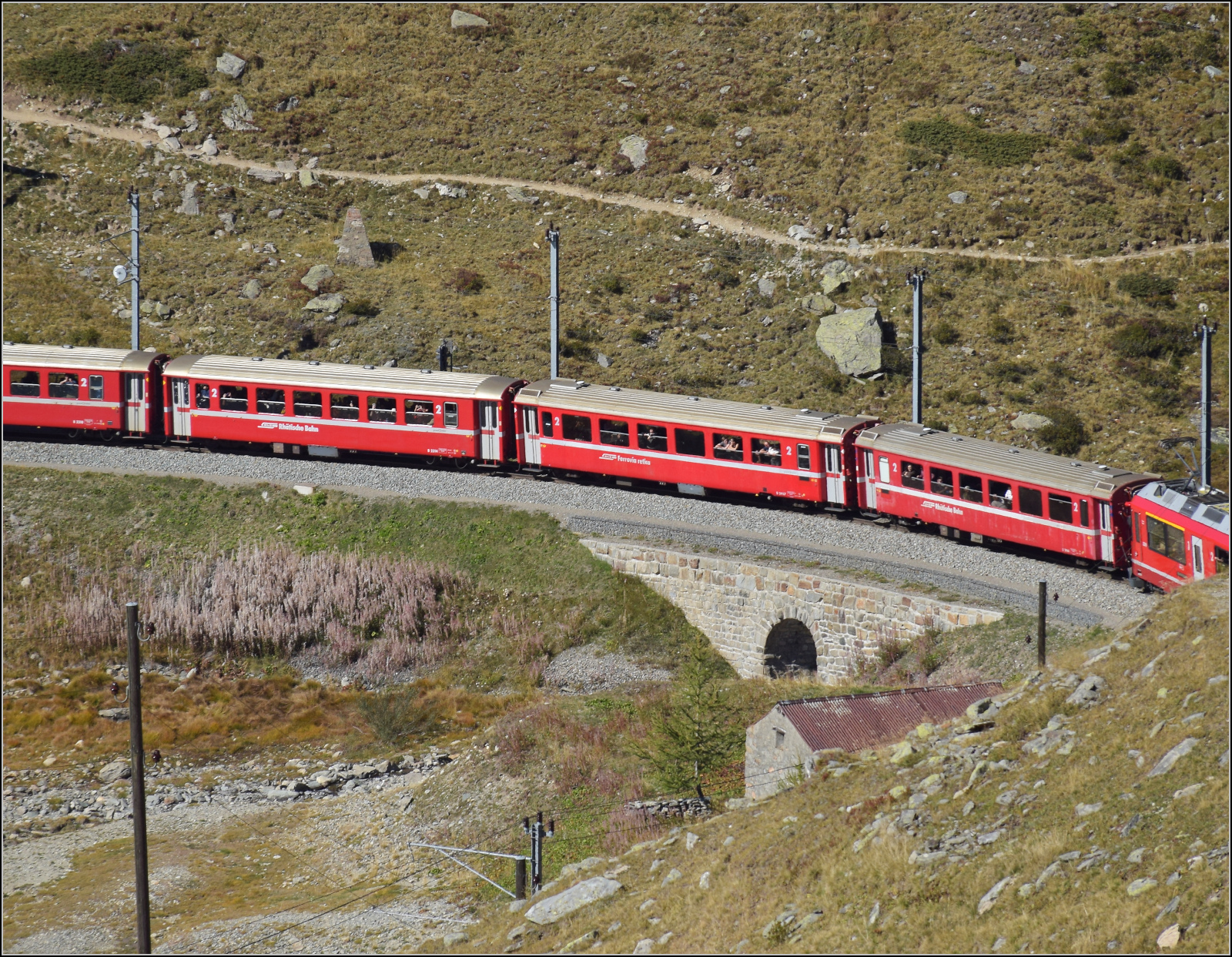 Der Wagen B 2314 links ist ein EW I in der kurzen Variante, der 1968 von FFA an die RhB geliefert wurde. Dann folgen B 2467 und vermutlich B 2463 sind zwei von nur 10 gebauten EW III. Sie wurden 1983 von FFA geliefert.

Im September versehen sie ihren Dienst in einem Regionalzug auf der Berninastrecke. Hier direkt auf der Gemeindegrenze zwischen Pontresina und Poschiavo am Lago Bianco. September 2026
