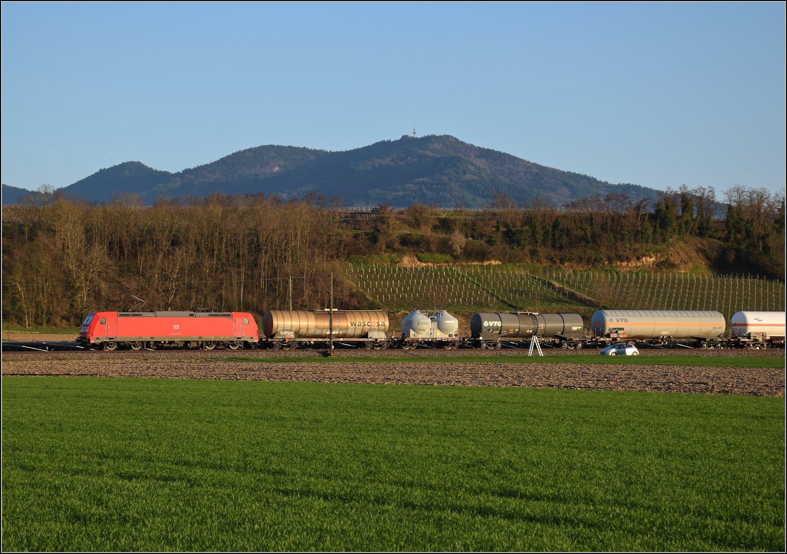 Die Abendstimmung hat längst eingesetzt als 185 270 mit einem Mischer bei Buggingen nordwärts vorbeizieht. Februar 2026.