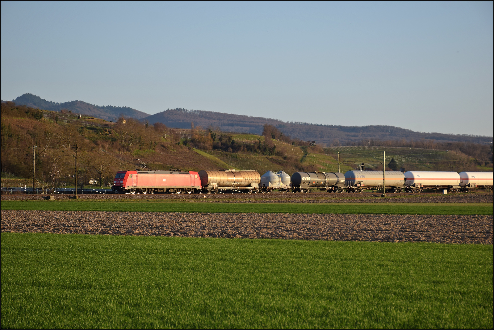 Die Abendstimmung hat längst eingesetzt als 185 270 mit einem Mischer bei Hügelheim nordwärts vorbeizieht. Februar 2026.