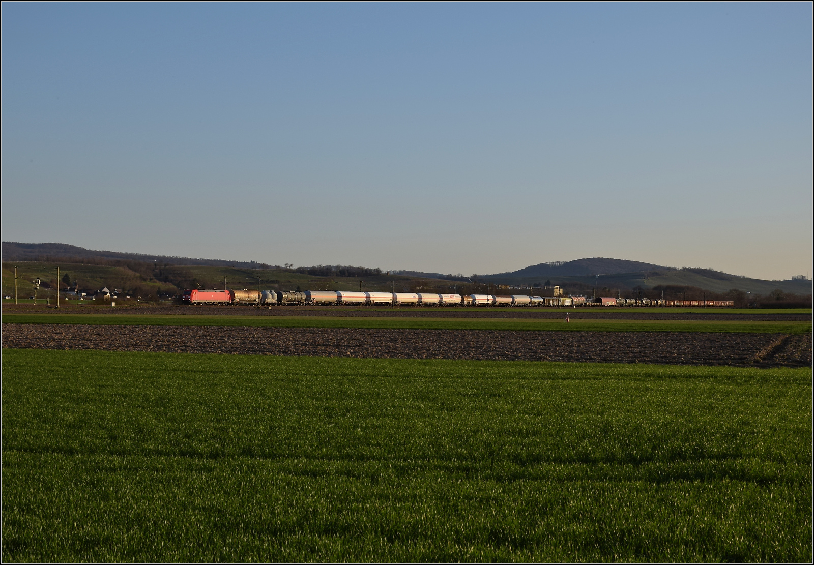 Die Abendstimmung hat längst eingesetzt als 185 270 mit einem Mischer bei Hügelheim nordwärts vorbeizieht. Februar 2026.