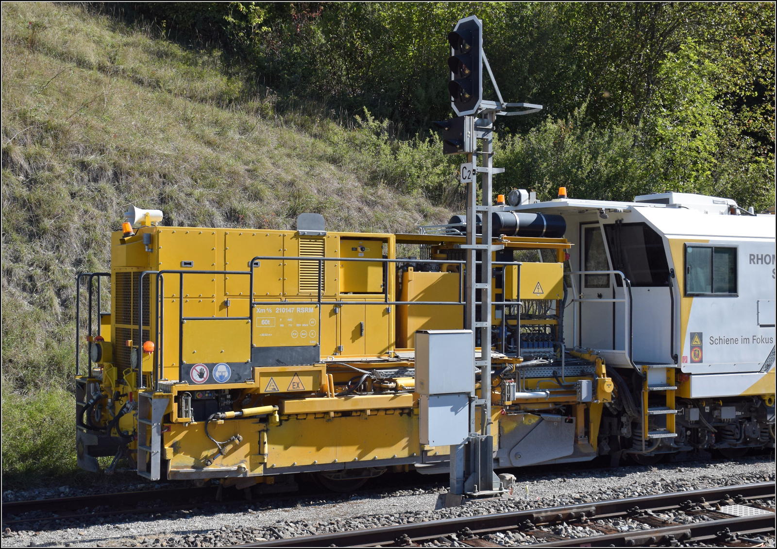 Die Planier- und Verdichtmaschine Xm 4/5 210147 ist eine R22RD-1 von Matisa in Diensten von Rhomberg-Sersa. Sie ist sehr kurz geraten, damit sie auf den Drehscheiben der RhB in Arbeitsrichtung gedreht werden kann. Hier der Einachsanh�nger im Bild. Sie ist neueren Datums und erst seit 2022 in Betrieb. Tiefencastel, September 2026.