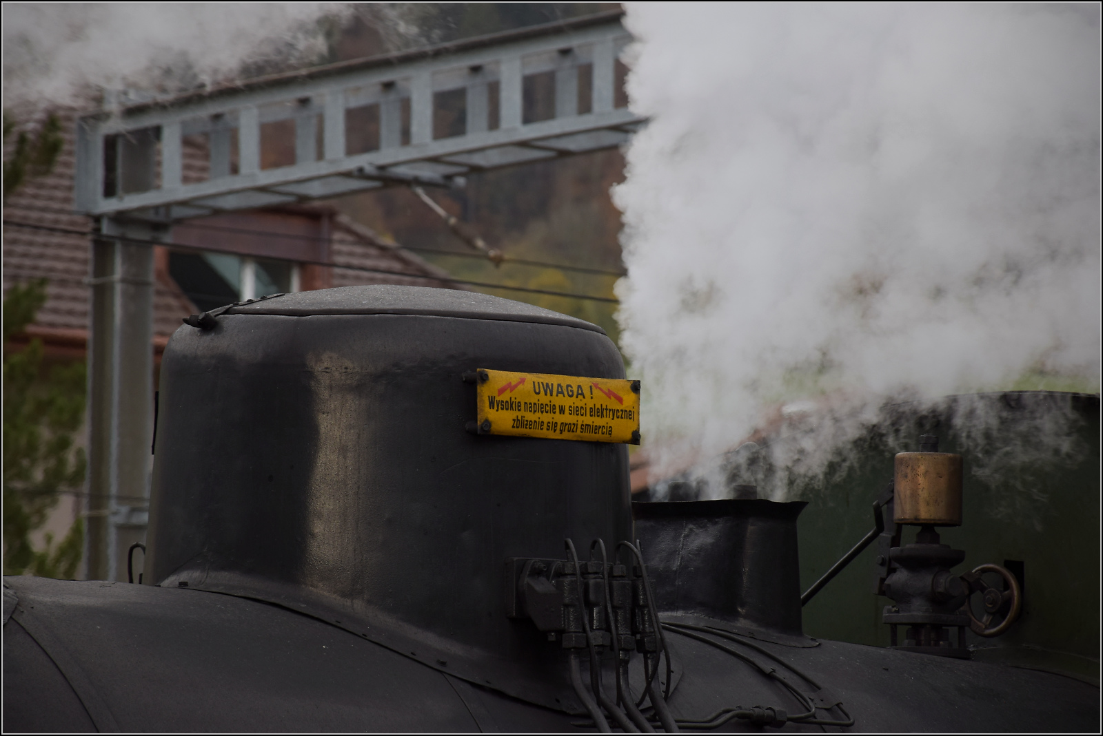 Die polnische Herkunft von TKp 16 'Śląsk' lässt sich nicht verleugnen, denn hier wird vor dem Strom der Oberleitung auf polnisch gewarnt. Travers, Oktober 2025.