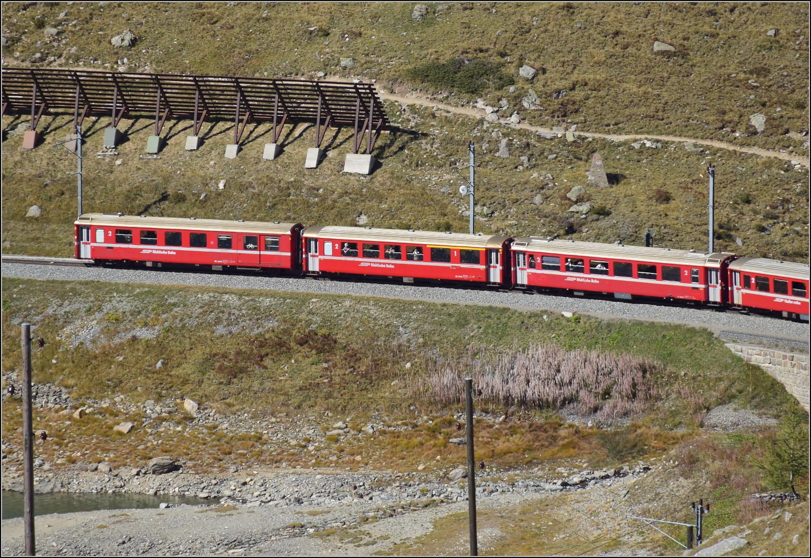 Die Wagen BD 2472, AB 1544 und B 2462 sind nicht nur alle drei verschiedene Wagentypen sondern auch von den Bauarten EW II, EW I und der seltene EW III (von links).

BD 2472 ist ein EW II in der kurzen Variante mit Gep�ckabteil, der 1982 von FFA geliefert wurde. 
AD 1544 ist ein gemischtklassiger EW I in der kurzen Variante, der 1968 von FFA geliefert wurde.
B 2462 ist einer von nur 10 EW III. Er wurde 1983 von FFA geliefert.

Im September versehen sie ihren Dienst in einem Regionalzug auf der Berninastrecke. Hier direkt auf der Gemeindegrenze zwischen Pontresina und Poschiavo am Lago Bianco. September 2026