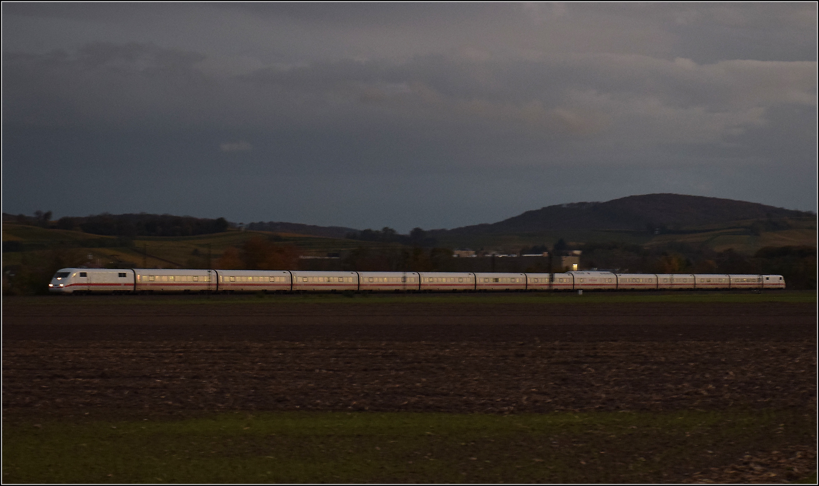 Eine heute sehr seltene Reminiszenz an vergangene Tage. Der immer noch lange 401 007 'Plattling' kommt aus der Schweiz im letzten Abendlicht gefahren. Seine Reise geht an diesem Tag nach Hamburg. Hügelheim, Oktober 2025.
