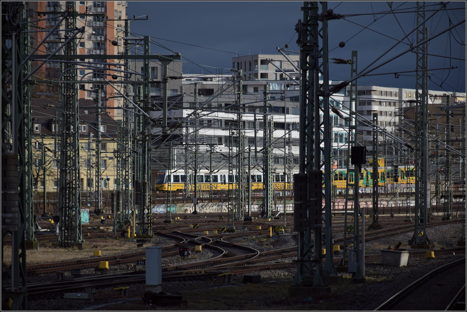 Eine Stadtbahn lugt durch den Mastenwald in Stuttgart. Februar 2026.