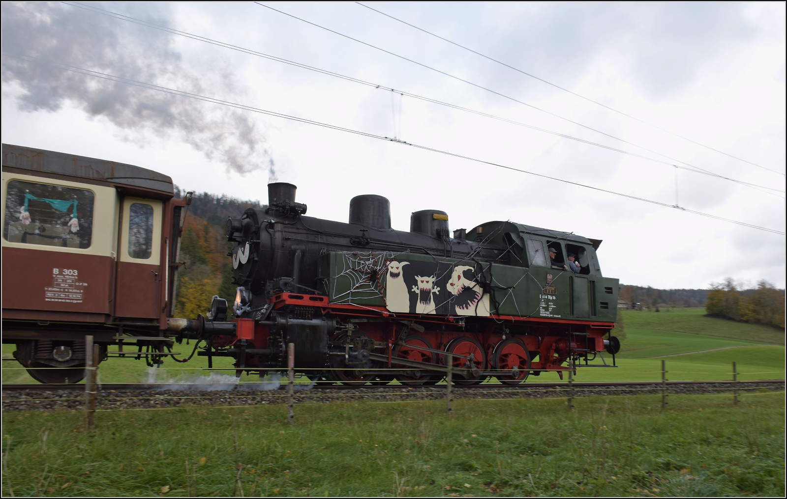 Gruseln zwischen Asphalt und Absinth.

TKp 16 'Śląsk' fährt mit ihrem Halloweenzug ins Val Travers herunter. Fin de Granges, Oktober 2025.