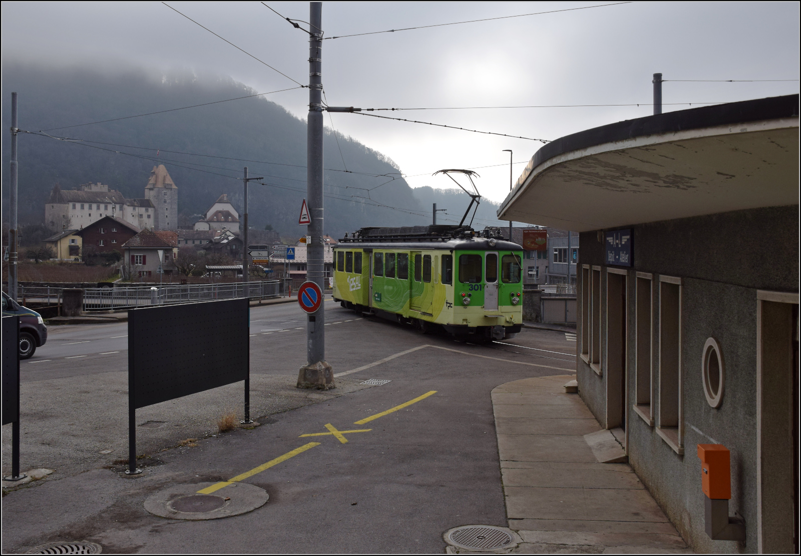 Im Depot gab es beim Warten auf die Einfahrt auch den Blick auf den Zug, dem wir im Konvoi gefolgt waren: Im Bild Be 4/4 302 der 1966 von der SIG und SAAS an die AL geliefert wurde, vor dem  Empfangsgeb�ude der AL, ganz im Stil einer Tankstelle der 1960er Jahre passend zum Zug. Ein wenig Antiquit�tenshow bei der AL extra f�r uns und zum Touristen Beeindrucken muss auch noch das Schloss Aigle ins Bild. Aigle Depot, Januar 2026.