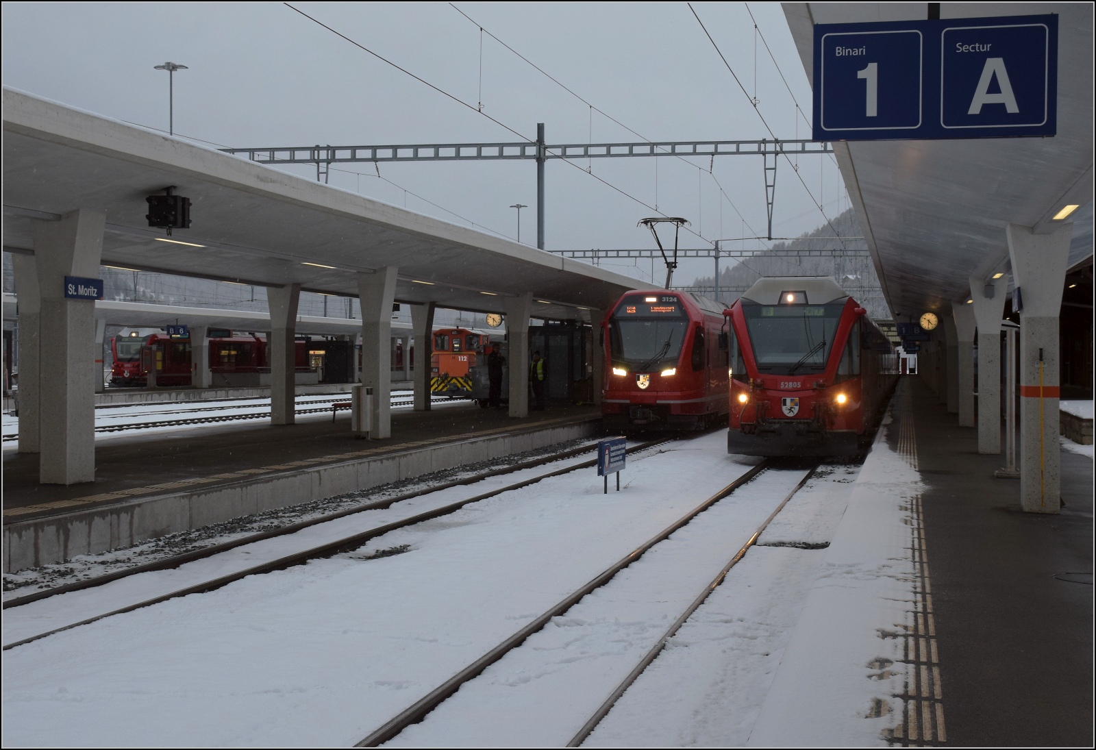 In St. Moritz stehen die neuesten Züge für die RhB abfahrbereit. Hinten der ABe 8/12 auf den Gleisen der Berninabahn nach Tirano, dazwischen hat sich die Rangierlok Tm 2/2 112 gemogelt, dann eine Doppeltraktion Capricorn ABe 4/16 nach Landquart mit Zug 3124 voraus, und rechts eine Alvra-Garnitur, geschoben von einer Ge 4/4 III. Januar 2023.