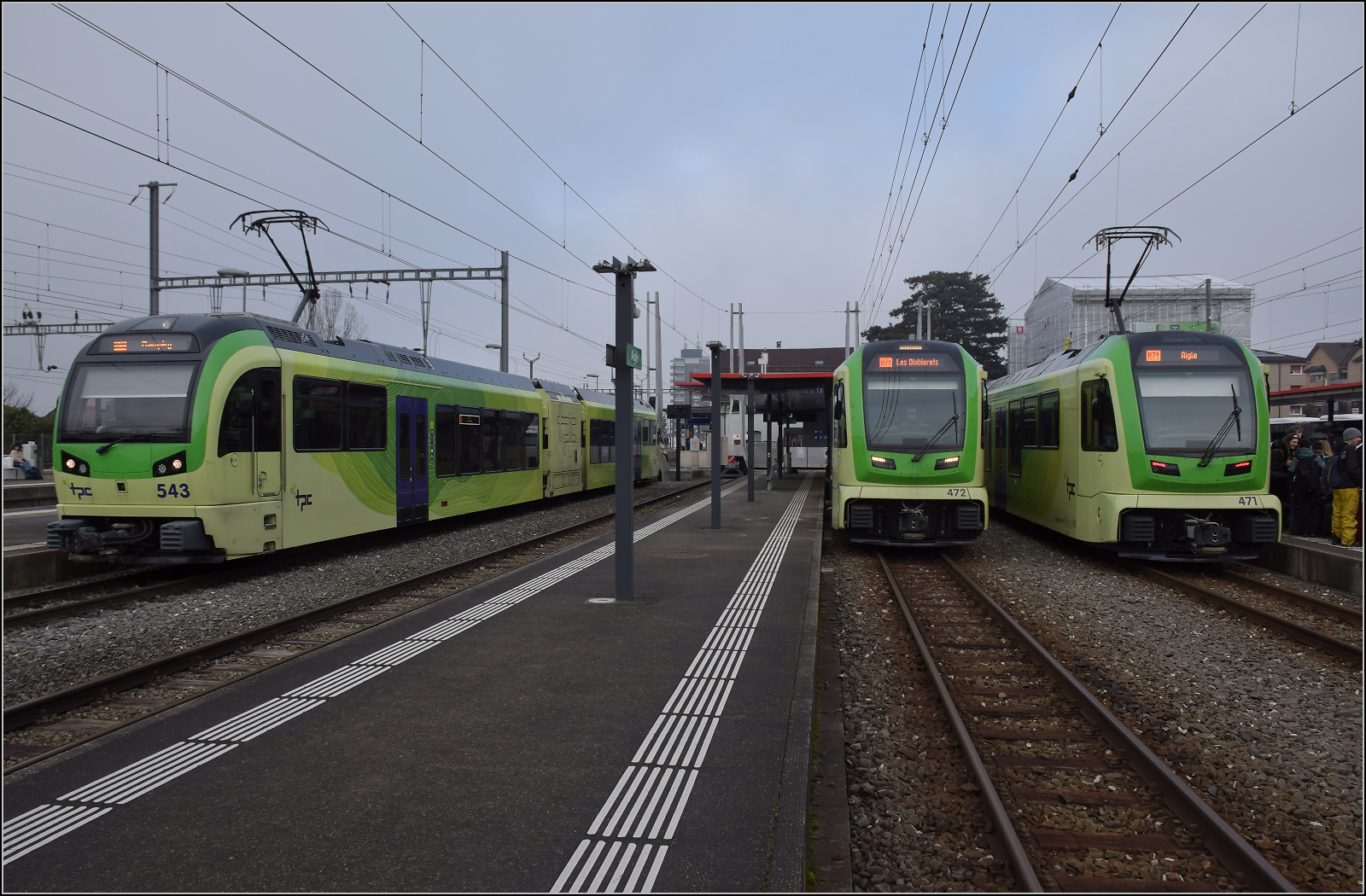 Links steht Beh 2/6 543 wartet auf seine Abfahrt in Richtung Monthey, von dort geht die Fahrt weiter nach Champéry. In der Mitte steht Be 4/8 472 für die Fahrt nach Les Diablerets bereit, während Be 4/8 471 gerade von dort eingetroffen ist. Aigle, Januar 2026.
