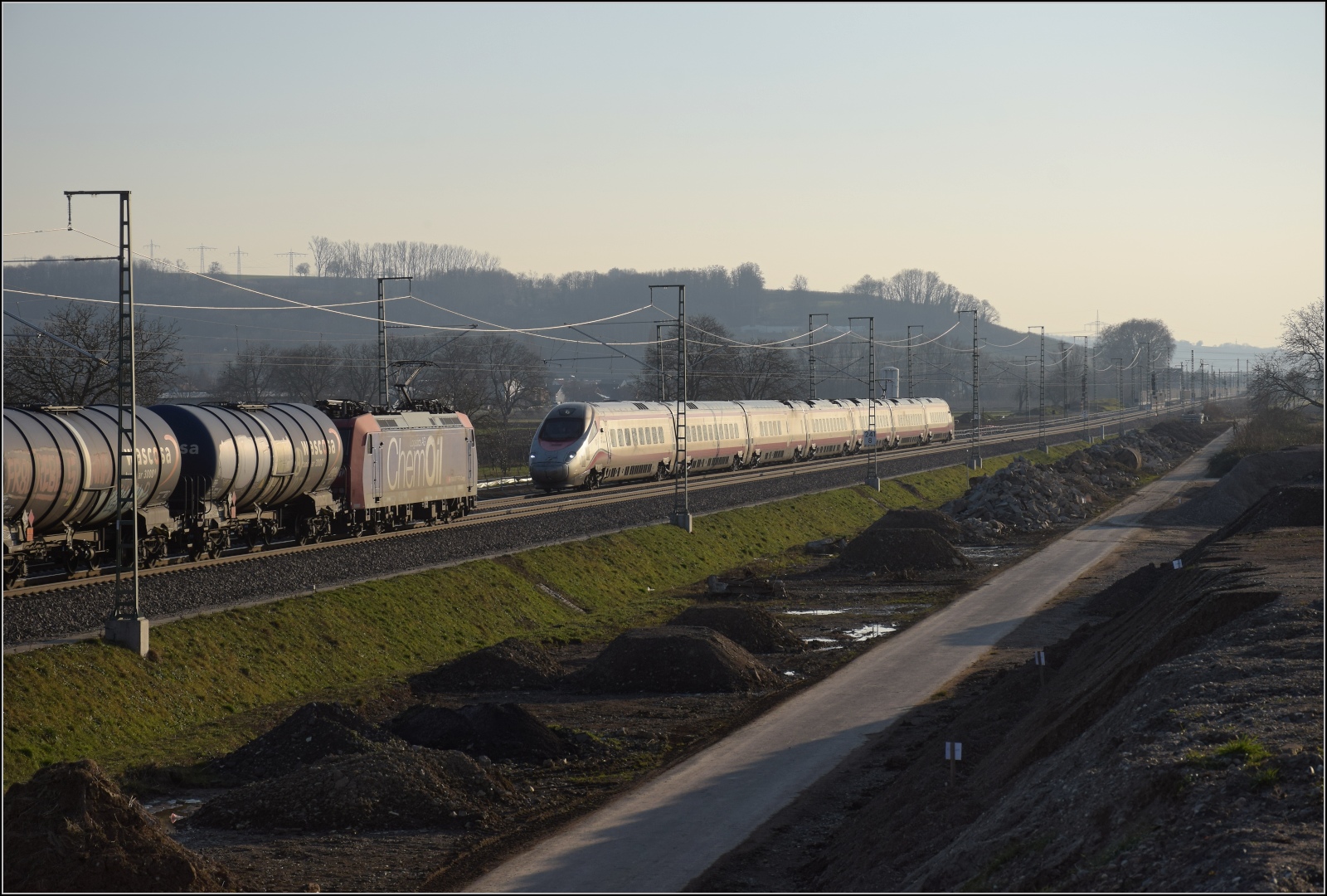 Nachmittag im Markgräfler Land. 

ETR 610 012 der Tren Italia begegnet der Re 482 028 'Chem Oil' mit einem Öler bei Auggen. Februar 2023.