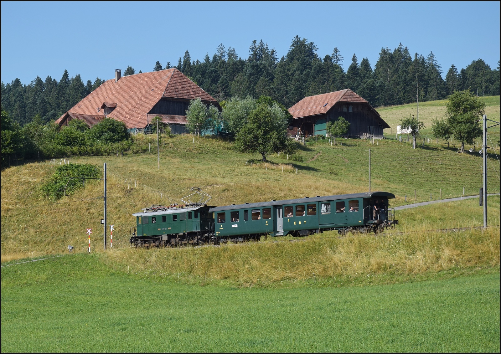 Öffentlicher Fahrtag auf der Emmentalbahn. 

Den Frühkurs von Huttwil zieht EBT Be 4/4 102 nach Sumiswald-Grünen. Griesbachmatten, Juli 2023.