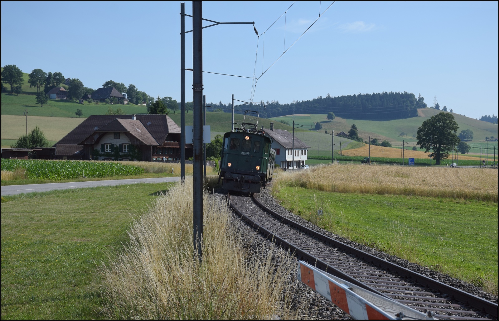 Öffentlicher Fahrtag auf der Emmentalbahn. 

Den Frühkurs von Huttwil zieht EBT Be 4/4 102 nach Sumiswald-Grünen. Waltrigen, Juli 2023.