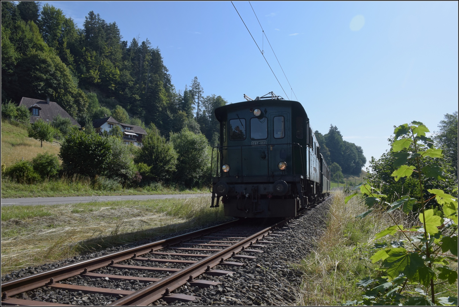 Öffentlicher Fahrtag auf der Emmentalbahn. 

Den Frühkurs von Huttwil zieht EBT Be 4/4 102 nach Sumiswald-Grünen. Fuchsloch, Juli 2023.